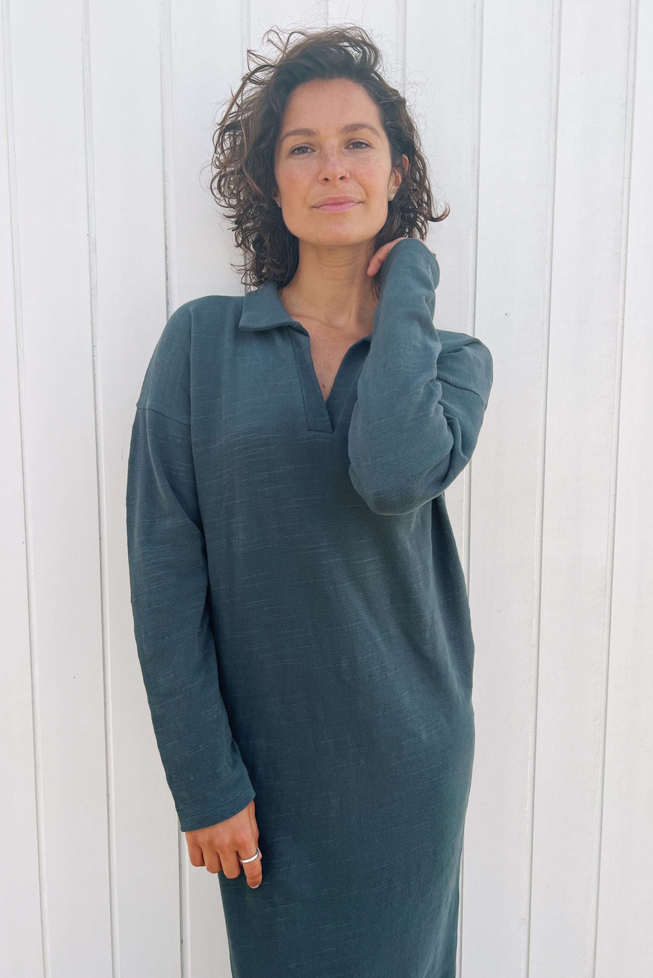 Long dress with long sleeves and a side slit in soft knitted fabric. The collar is finished with a buttonless V-neckline and a collar design.