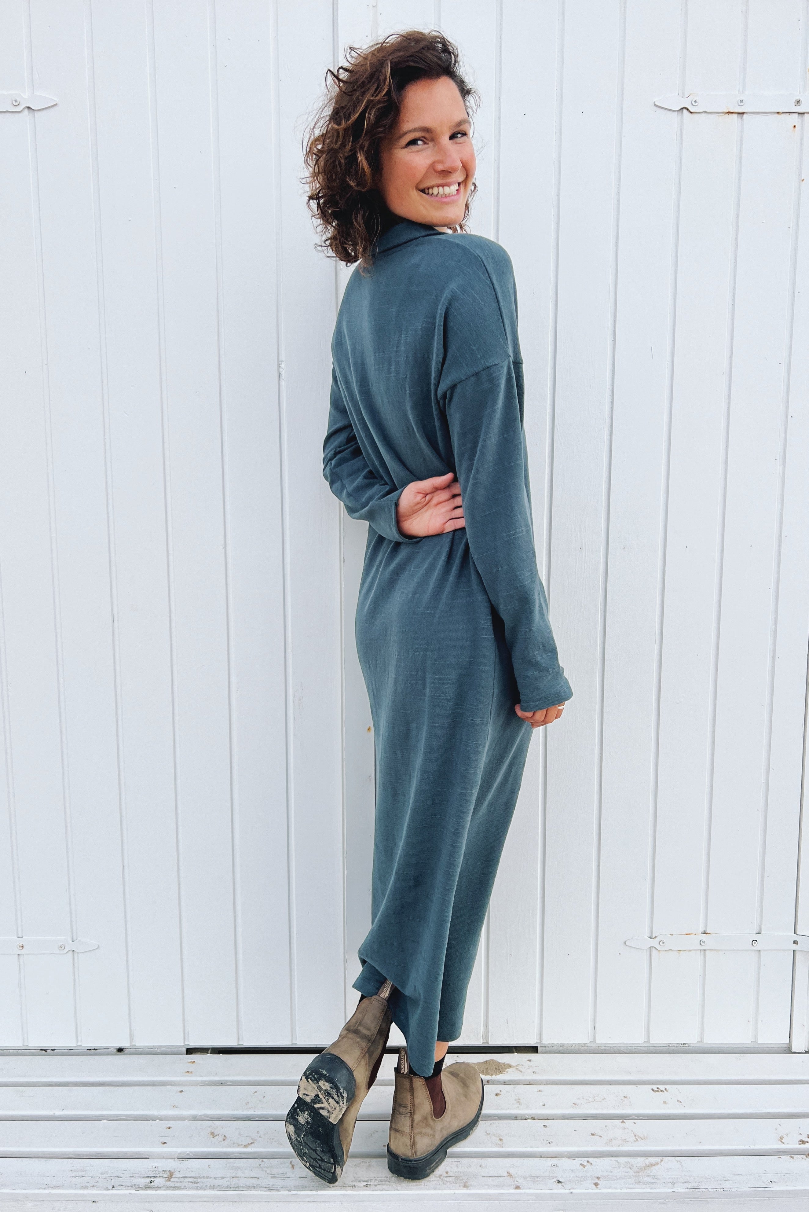 Long dress with long sleeves and a side slit in soft knitted fabric. The collar is finished with a buttonless V-neckline and a collar design.
