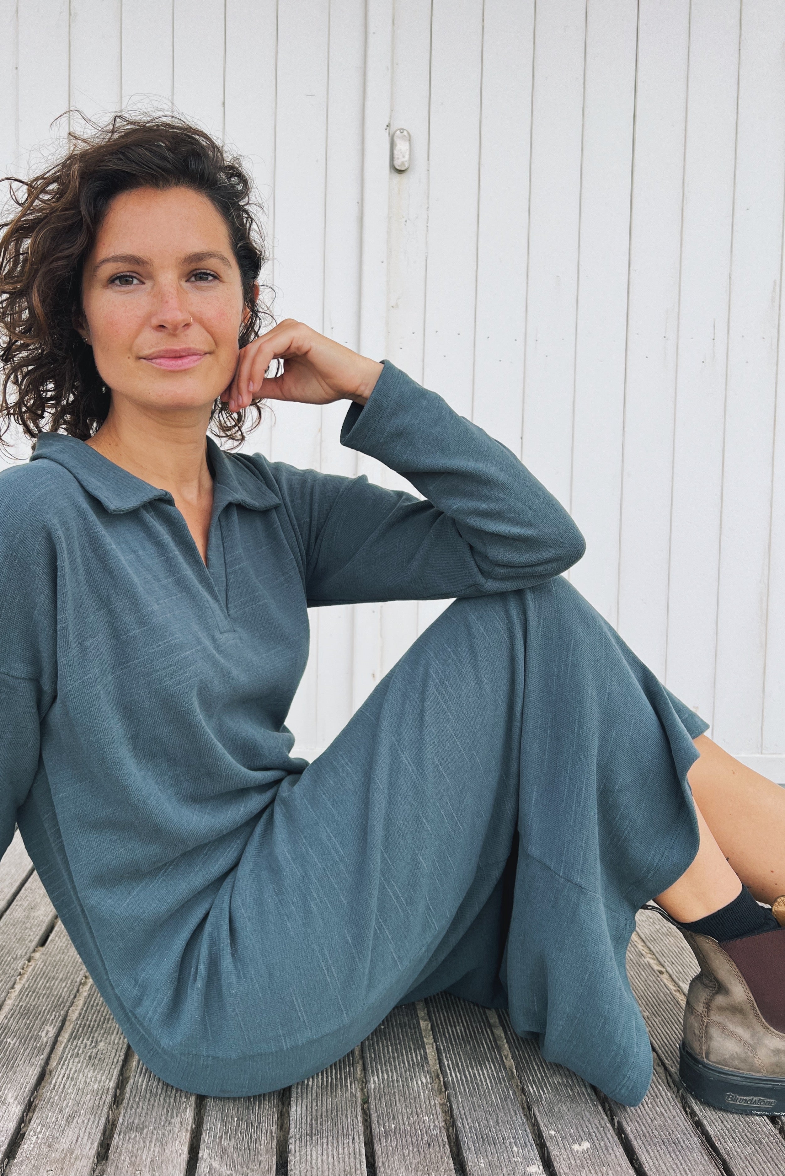 Long dress with long sleeves and a side slit in soft knitted fabric. The collar is finished with a buttonless V-neckline and a collar design.