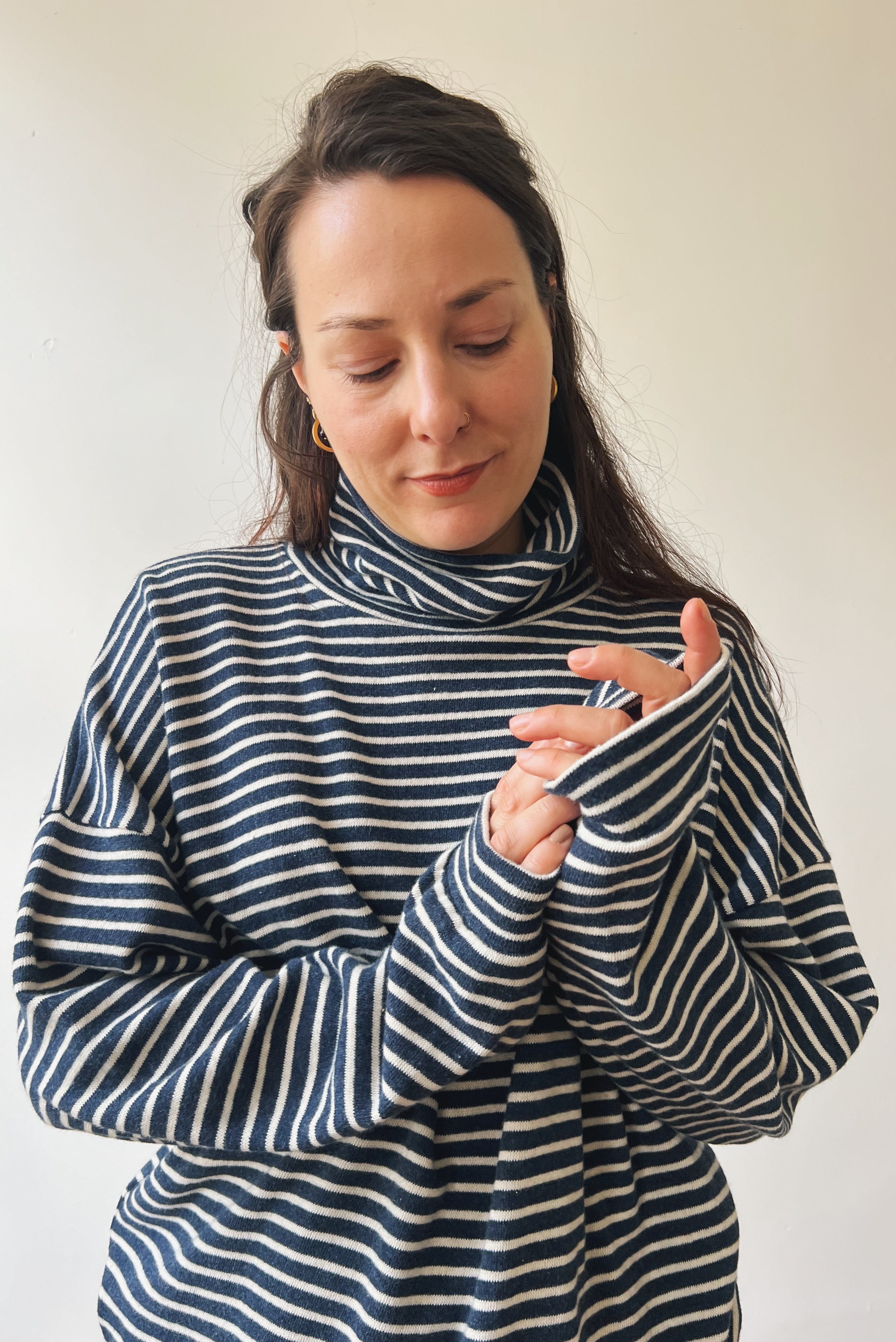Woman wearing a blue and white striped sweater against a plain background