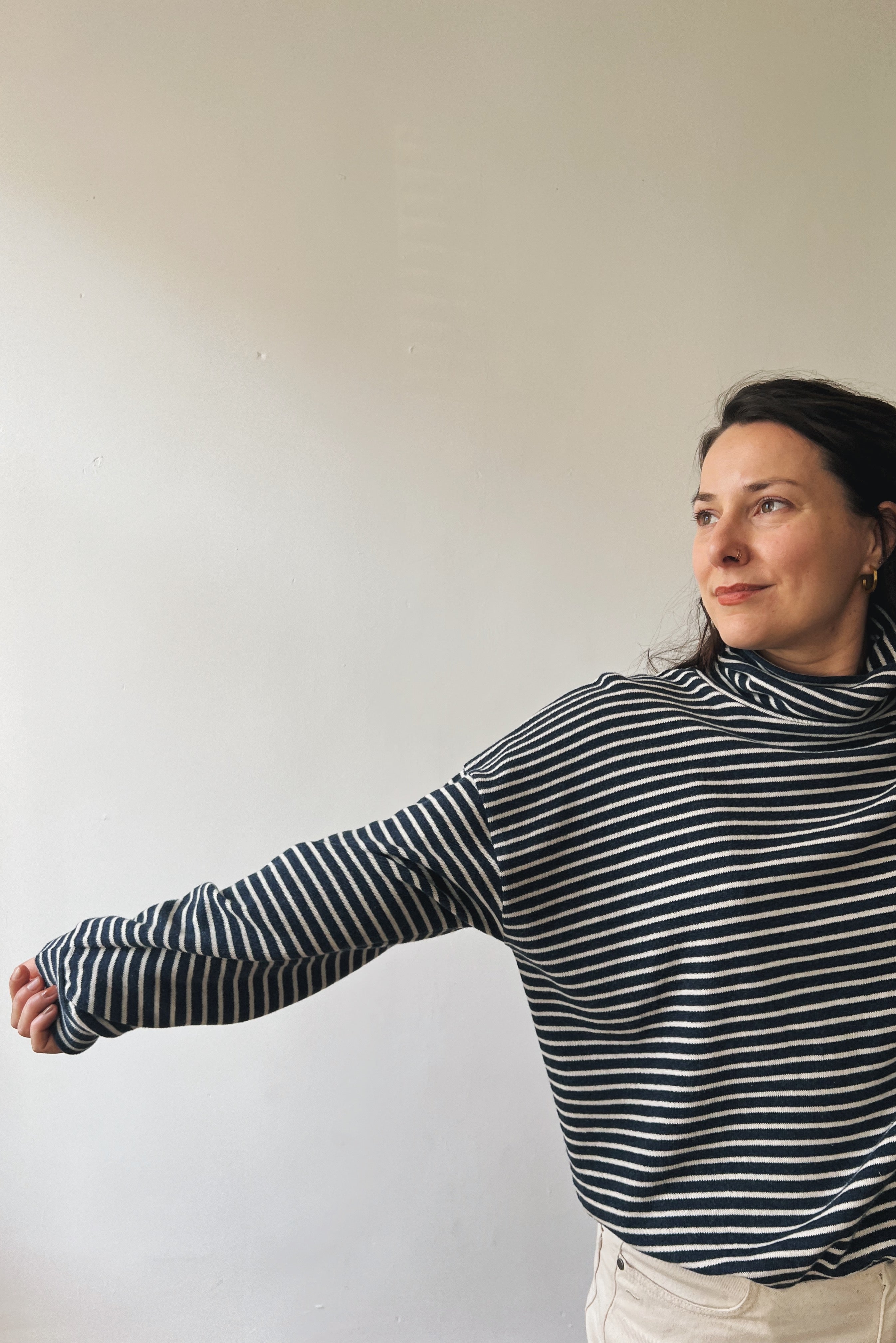 Woman wearing a black and white striped sweater against a plain background