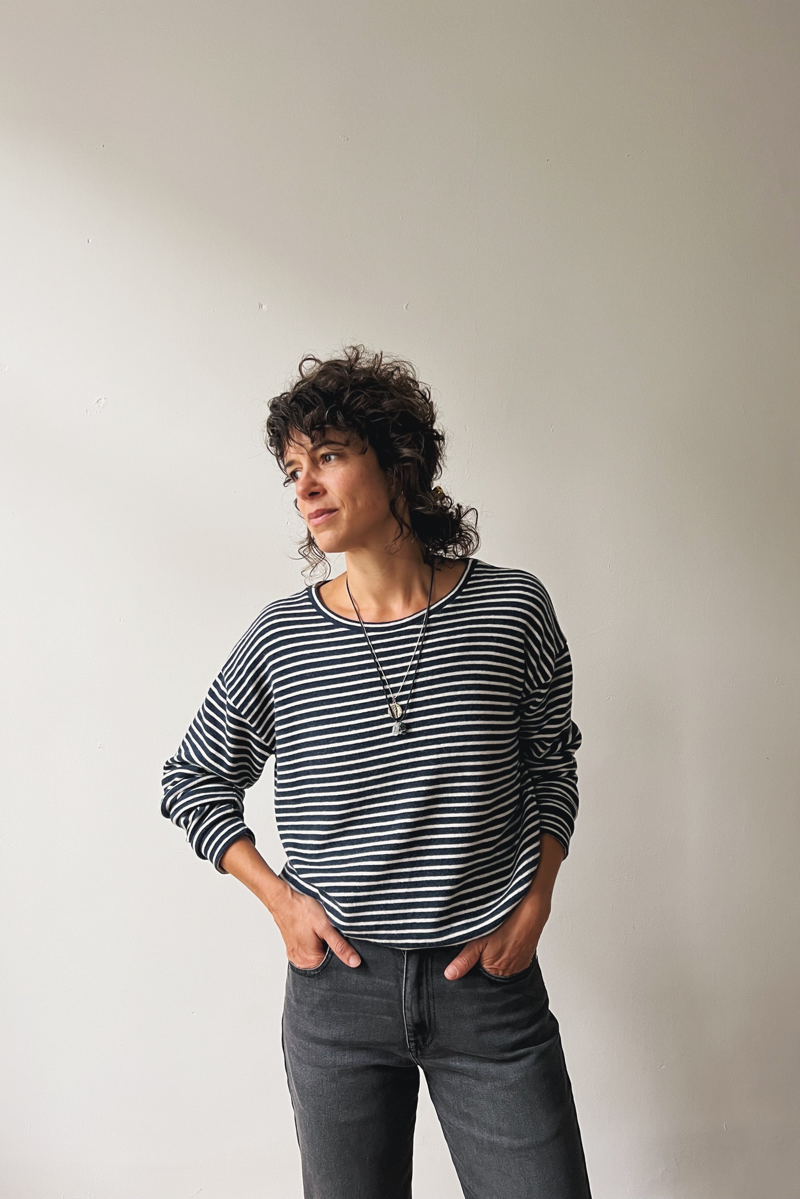 Woman wearing a blue and white striped sweater against a plain background