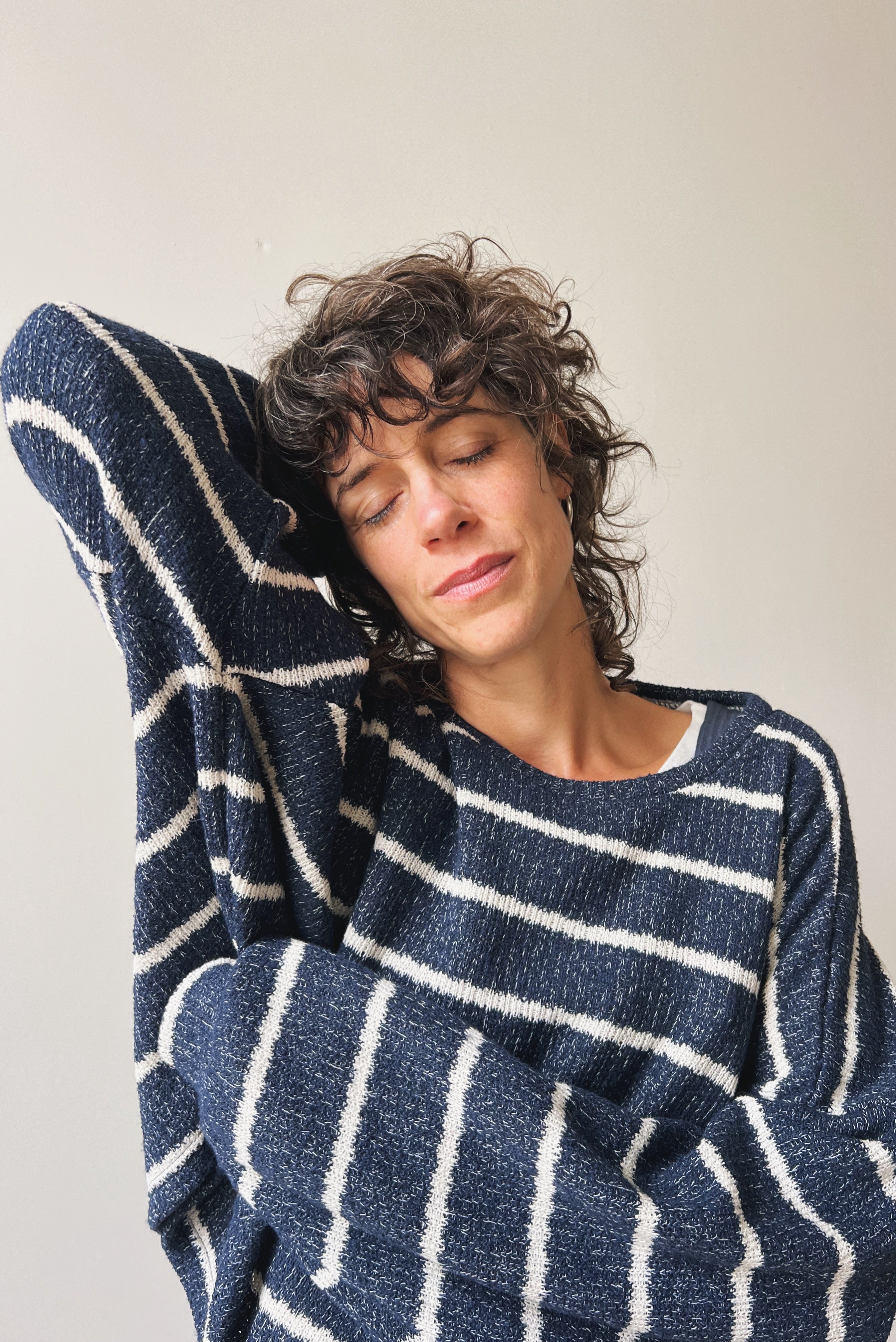 Person wearing a blue and white striped sweater enjoying the soft fabric