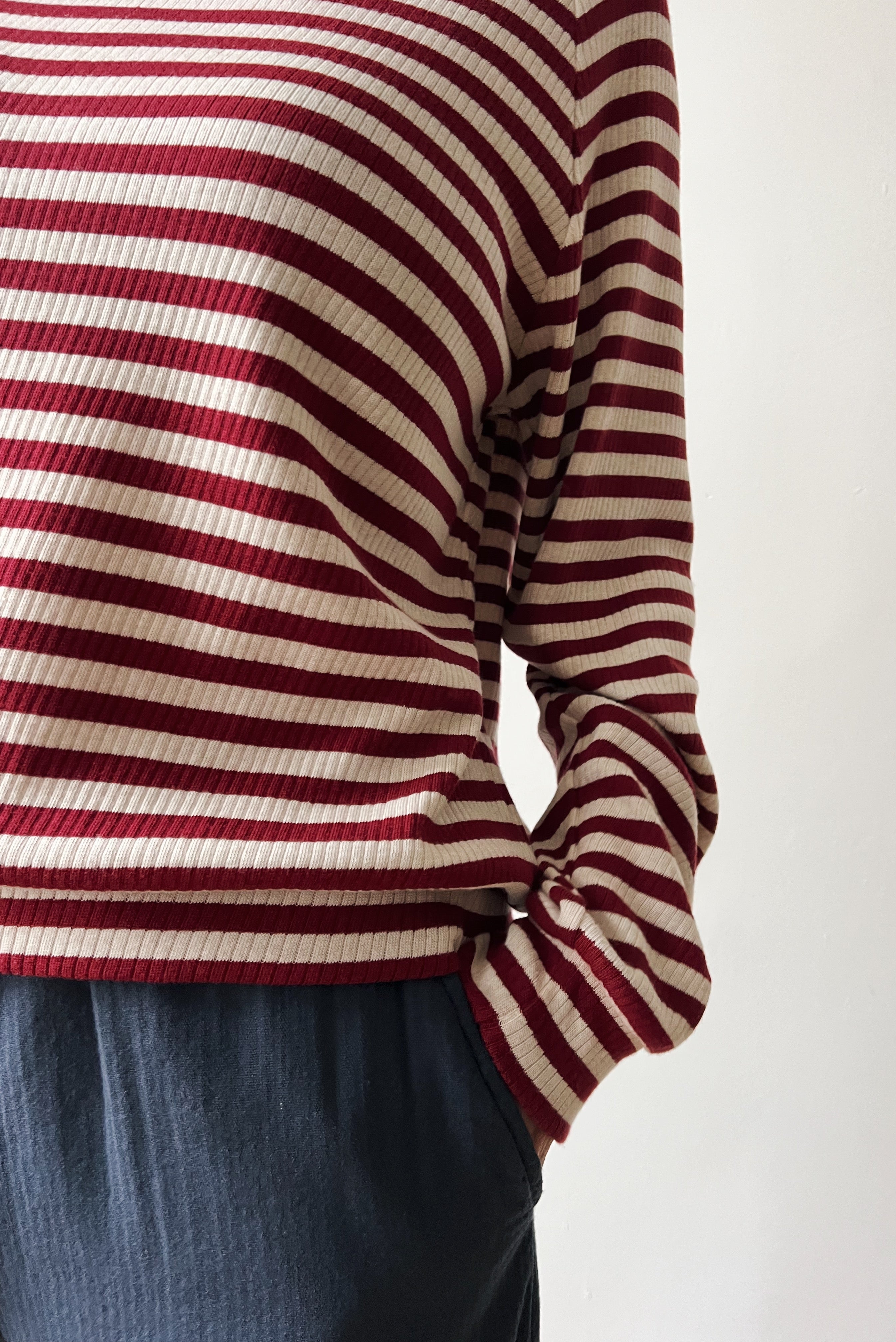 Red and white striped sweater worn by a woman on a plain background