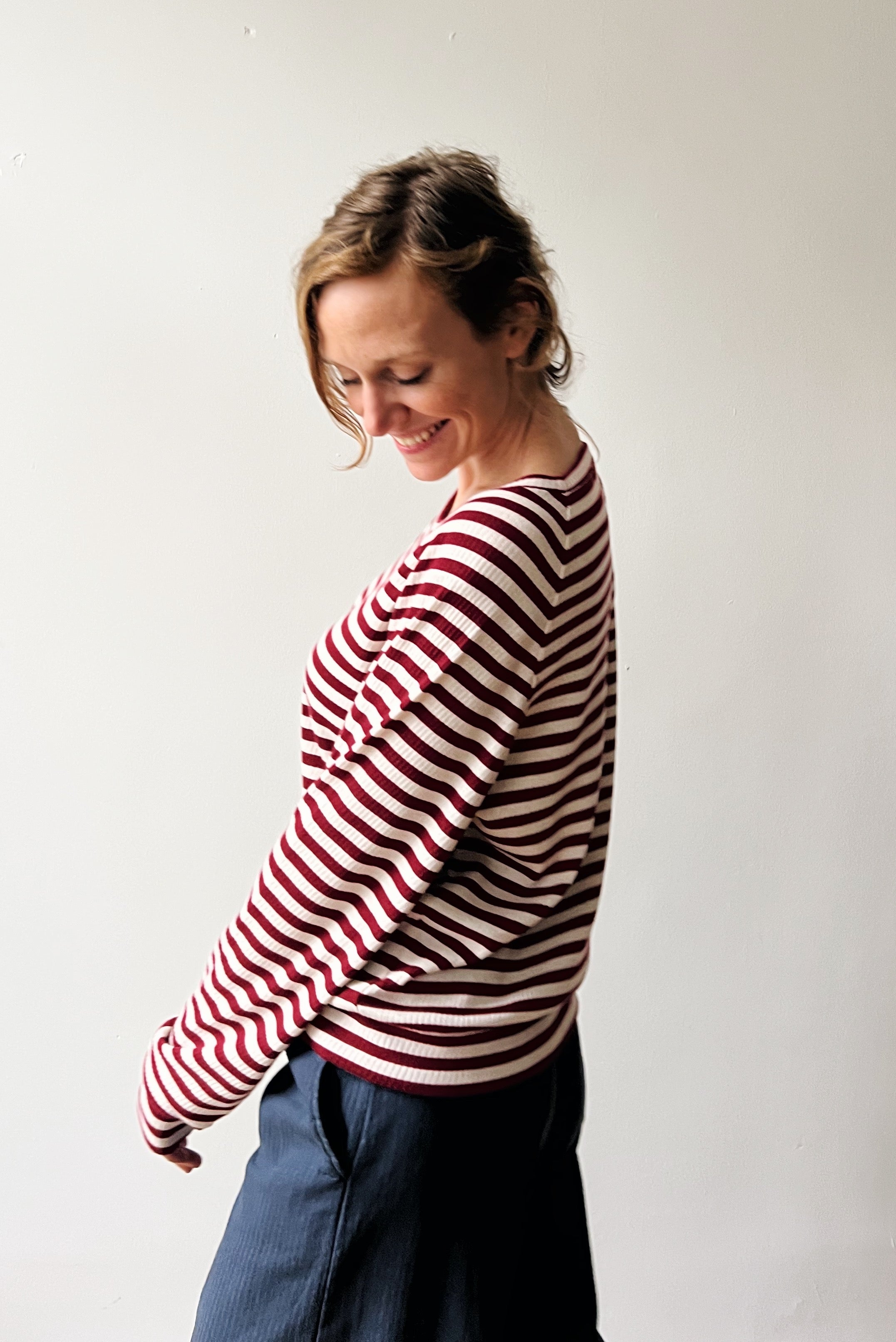 Woman wearing a red and white striped sweater against a plain background