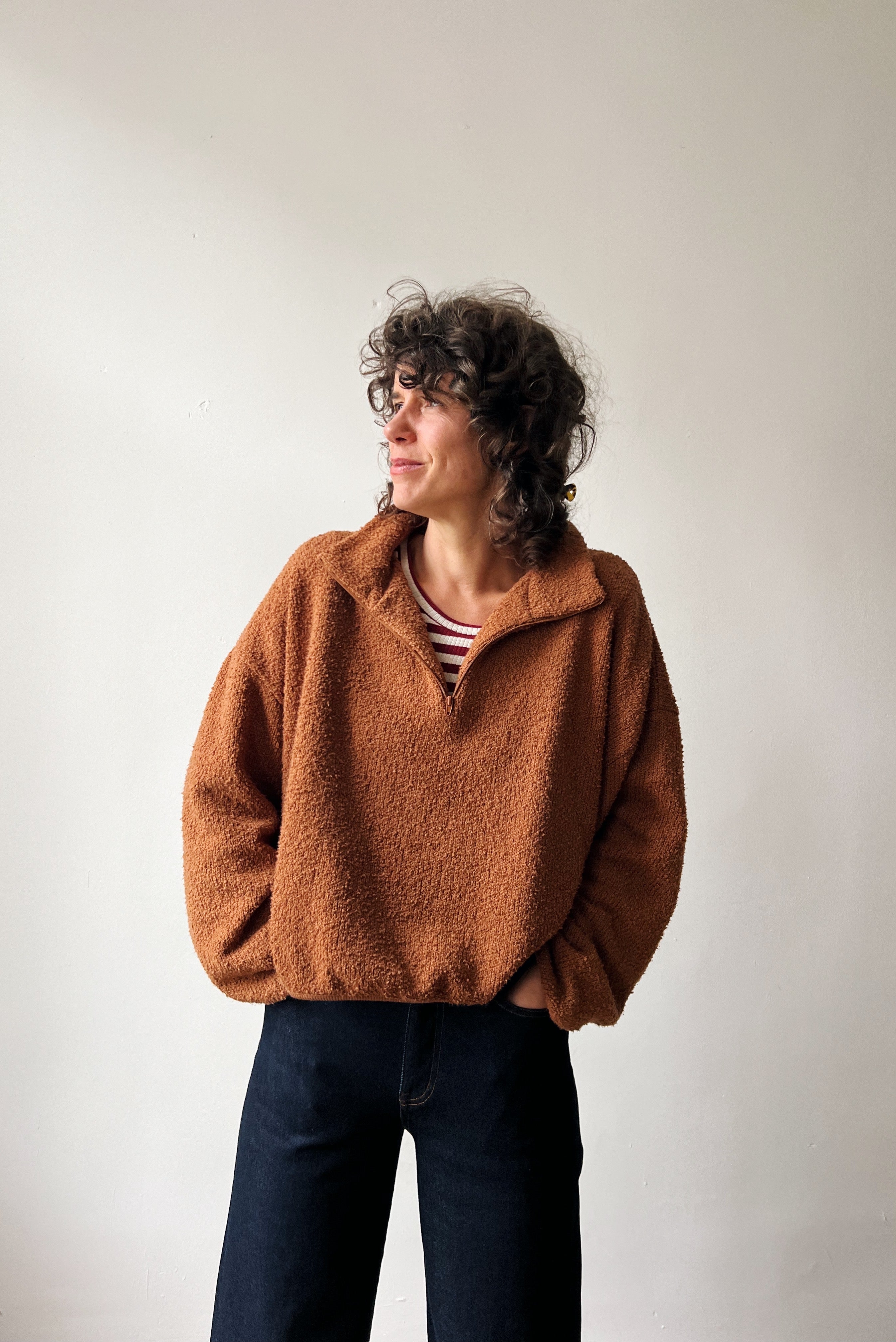 Person wearing a brown fleece pullover against a plain background