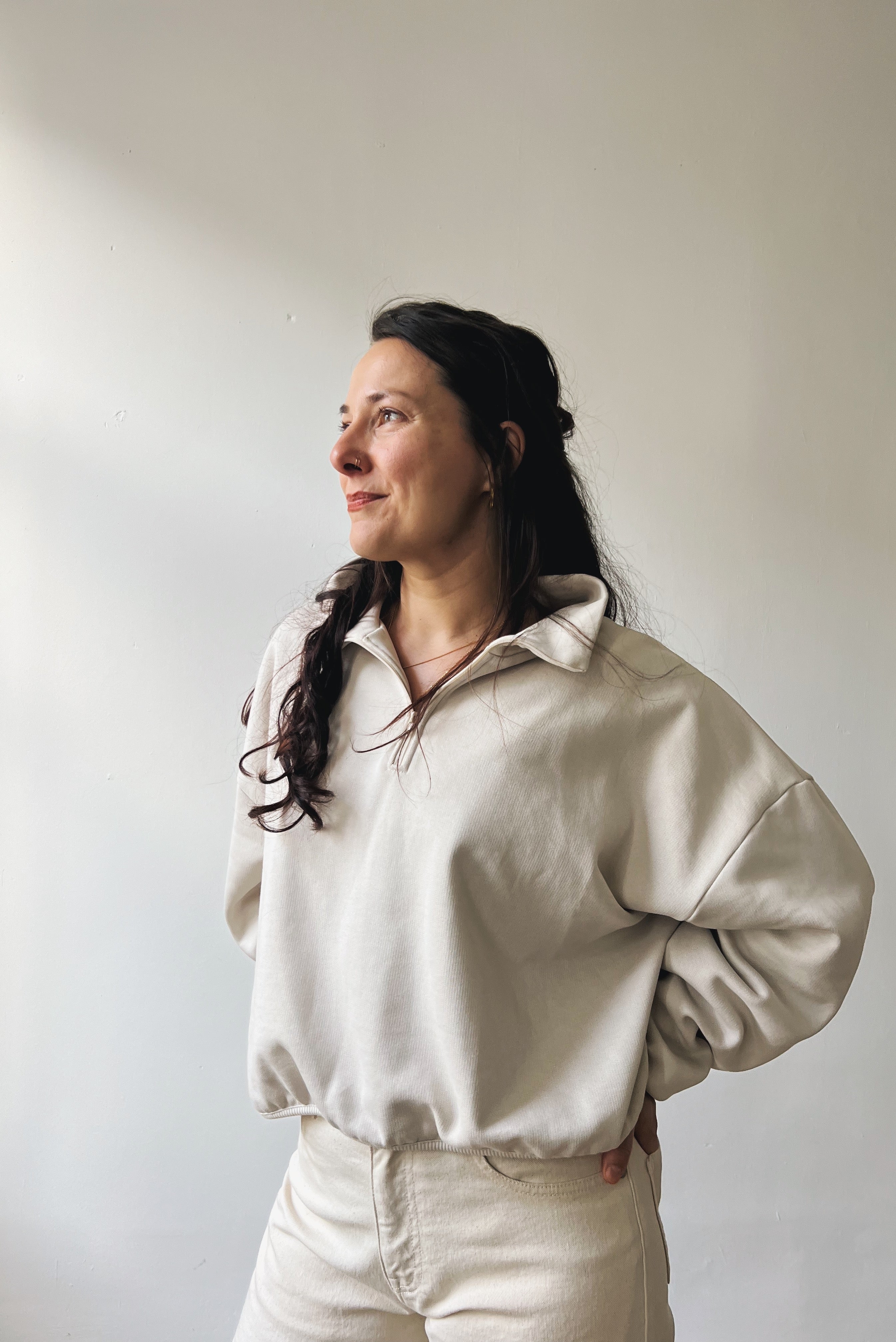 Woman wearing a beige sweater against a plain background