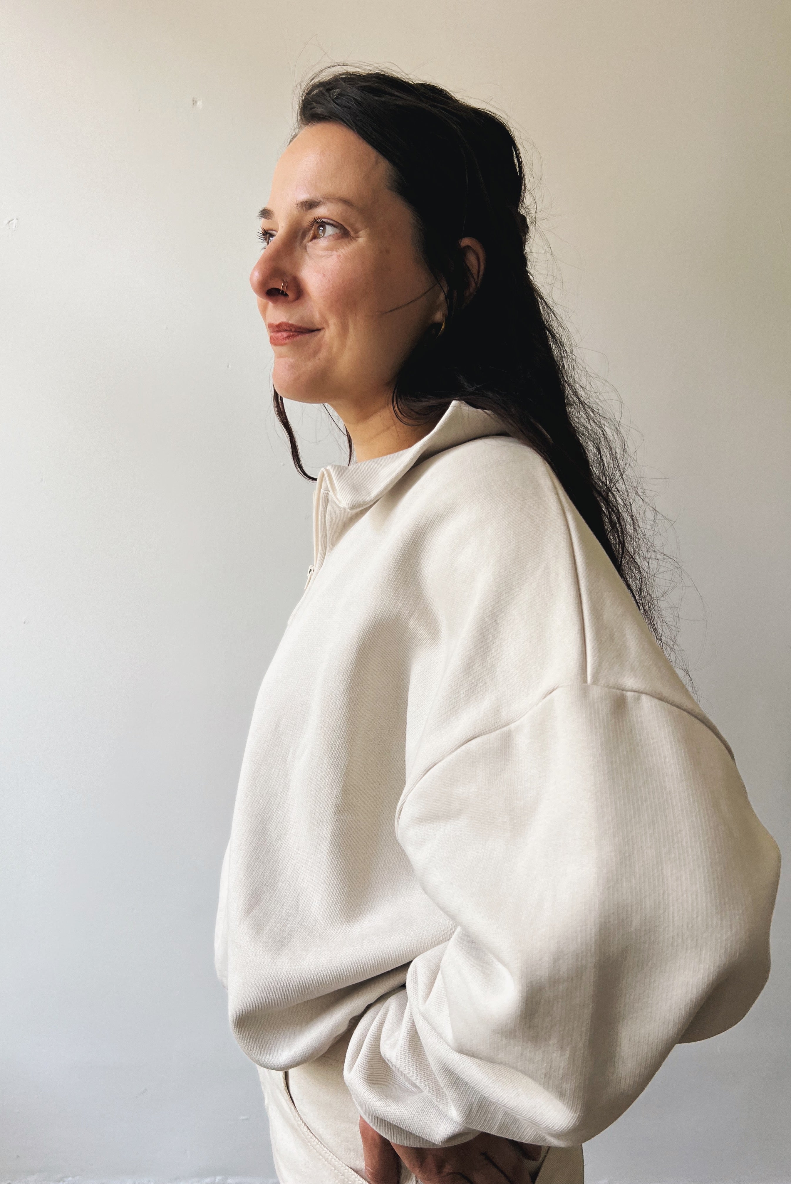 Woman wearing a beige sweater against a plain background