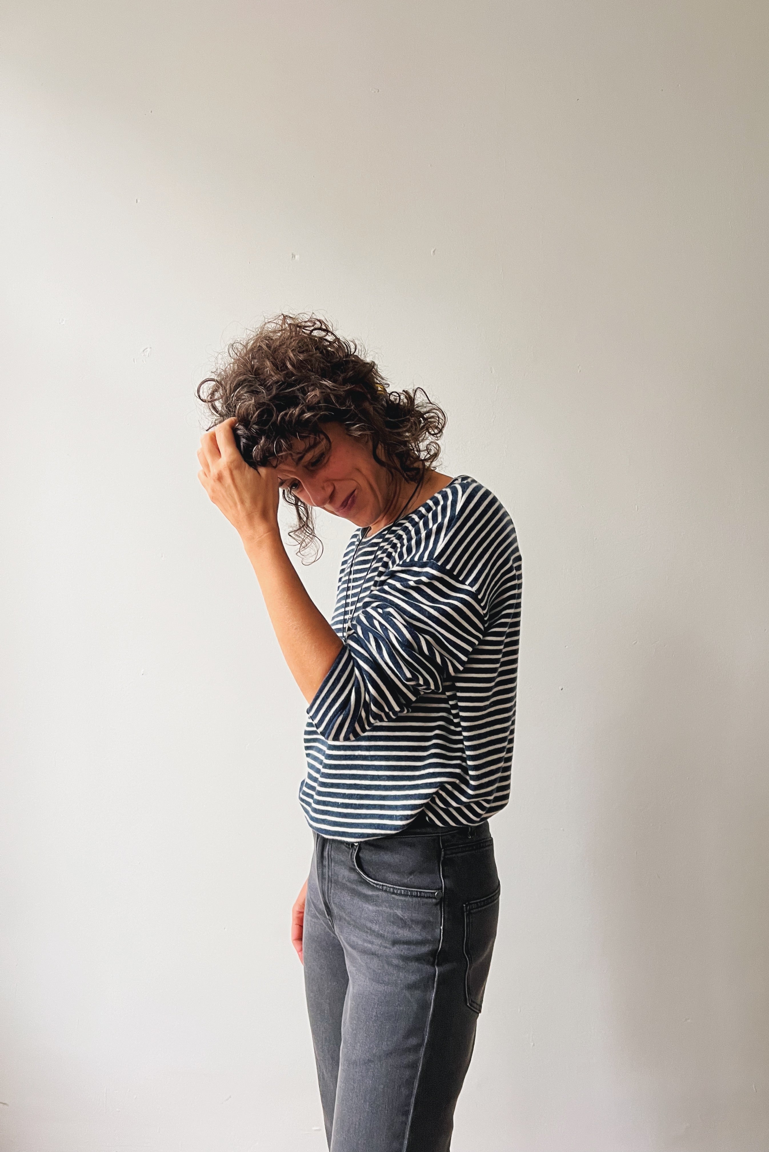 Woman wearing a striped sweater and dark grey boyfriend jeans