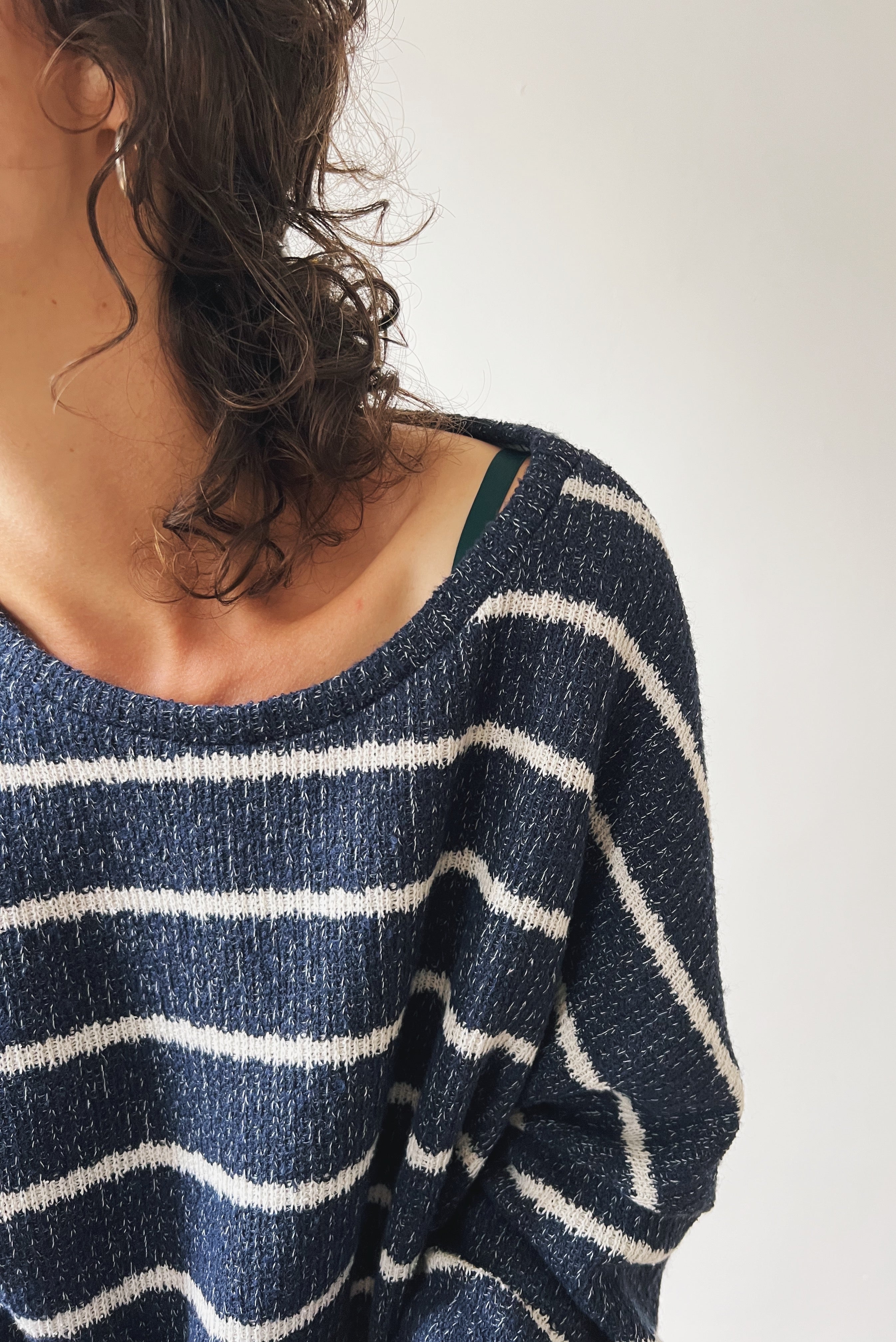 Close-up of a person wearing a blue and white striped sweater against a plain background
