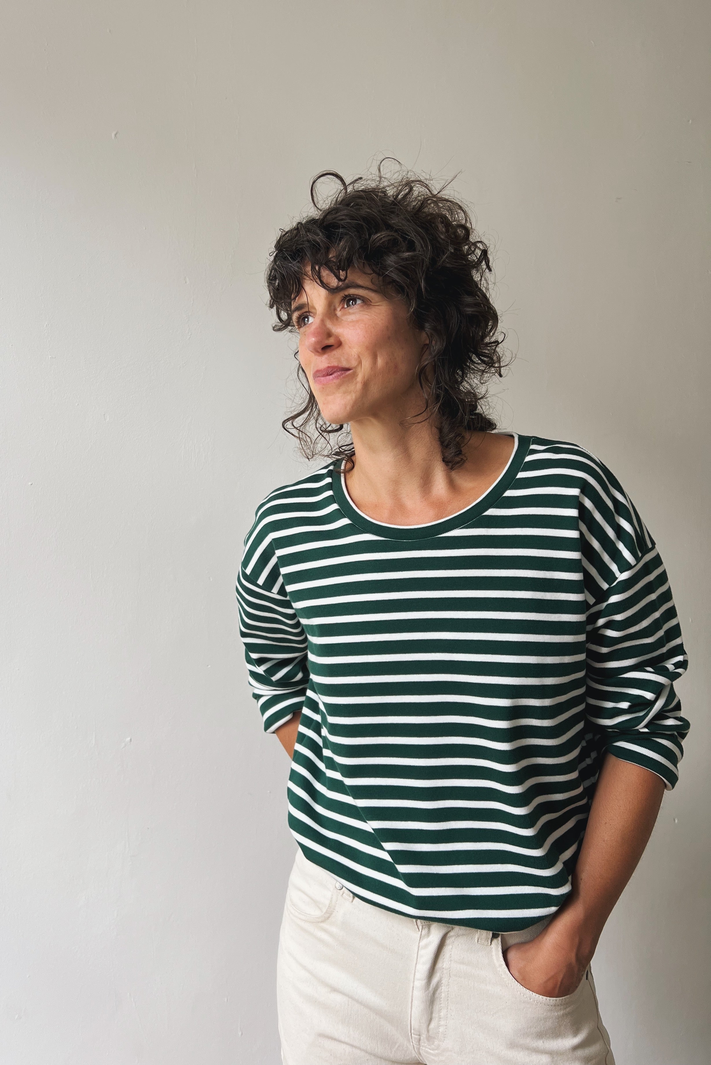 Person wearing a green and white striped shirt against a plain background