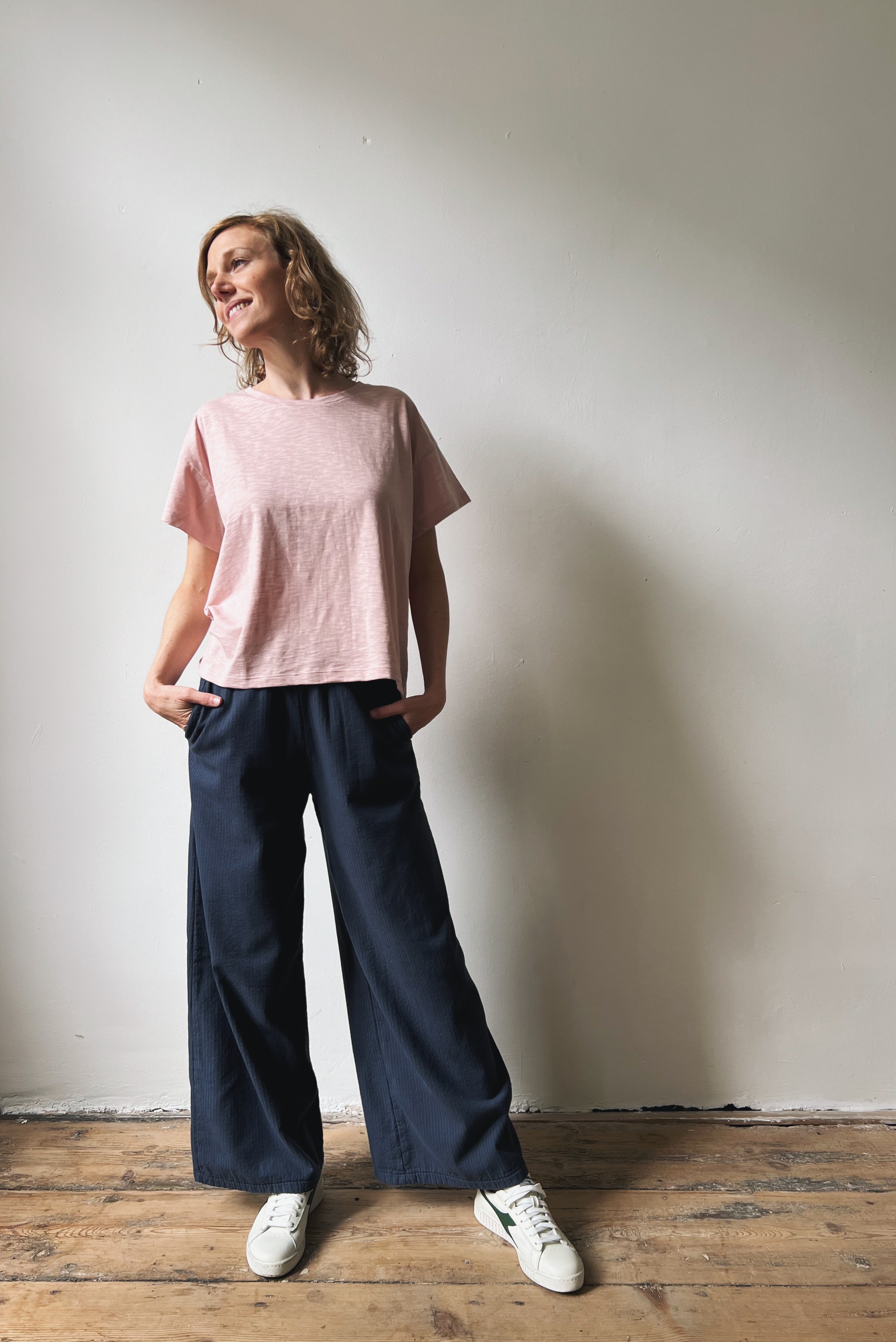 Woman wearing a pink top and navy pants