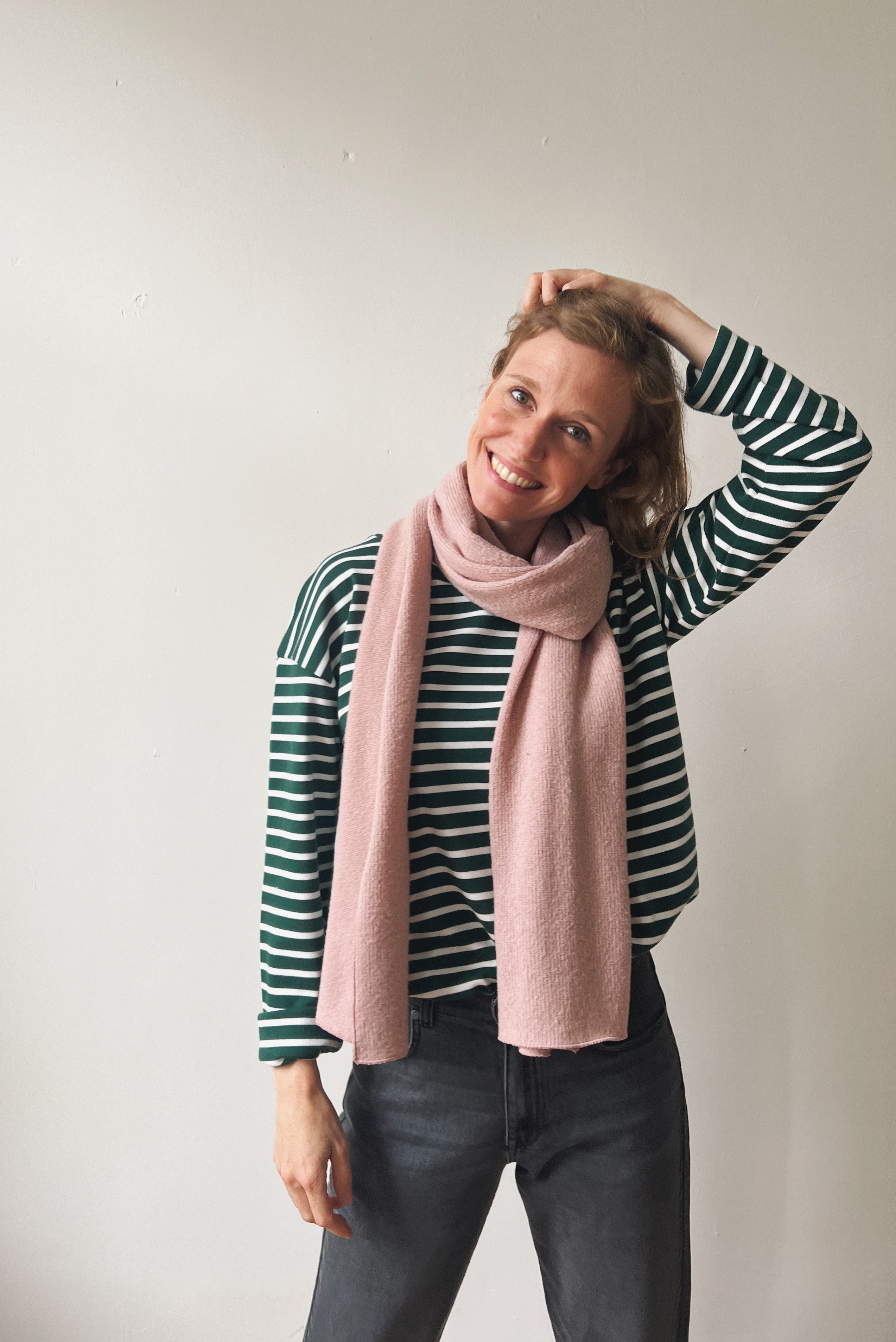 Woman wearing a striped shirt and pink scarf