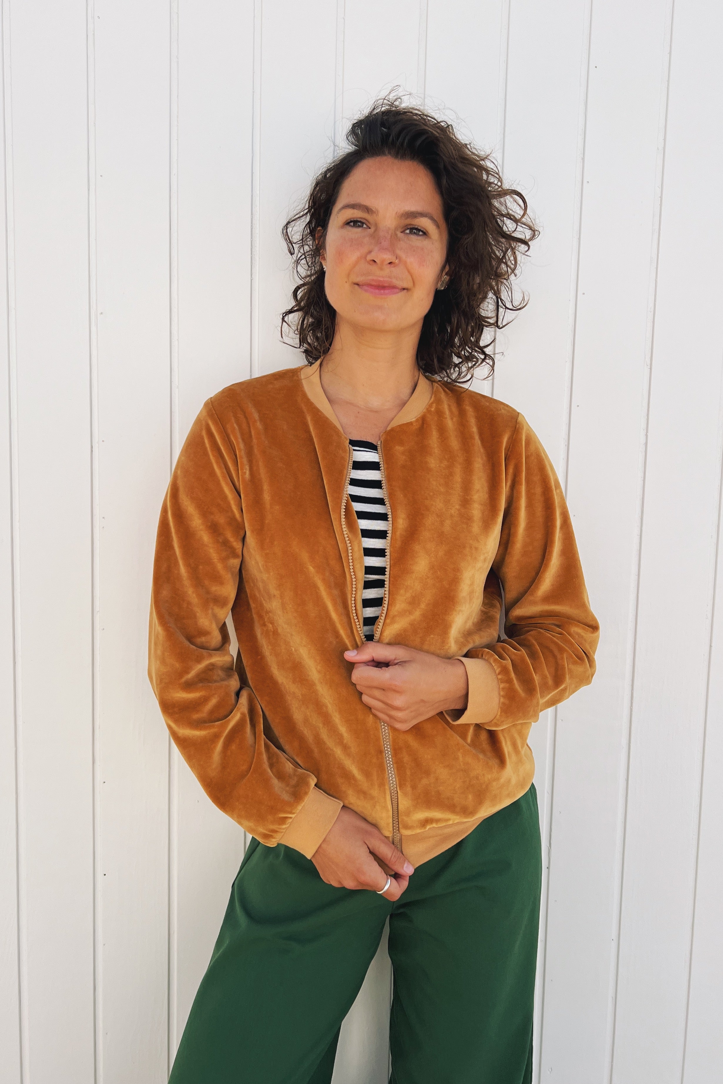 Bomber jacket in soft velour with front pockets, finished with ribbed cuffs, collar, and waistband, and featuring a zip closure.