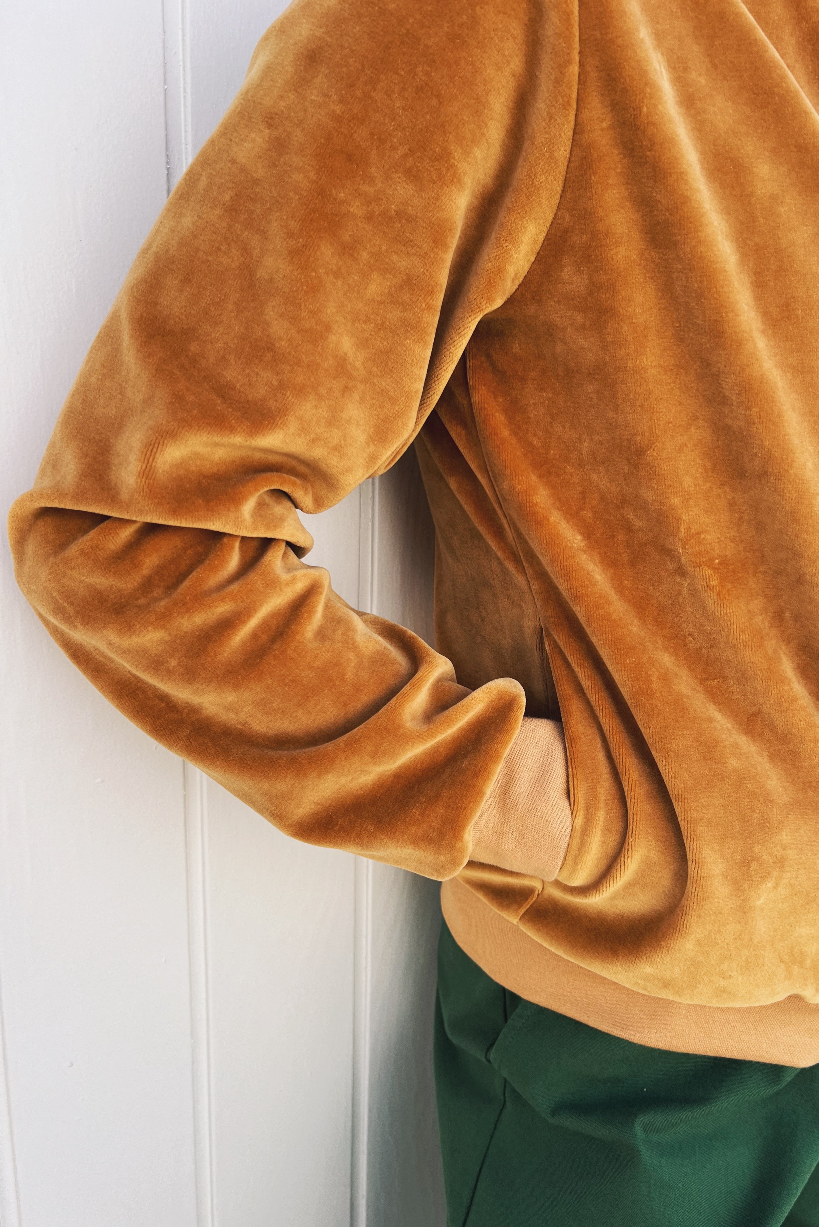 Bomber jacket in soft velour with front pockets, finished with ribbed cuffs, collar, and waistband, and featuring a zip closure.