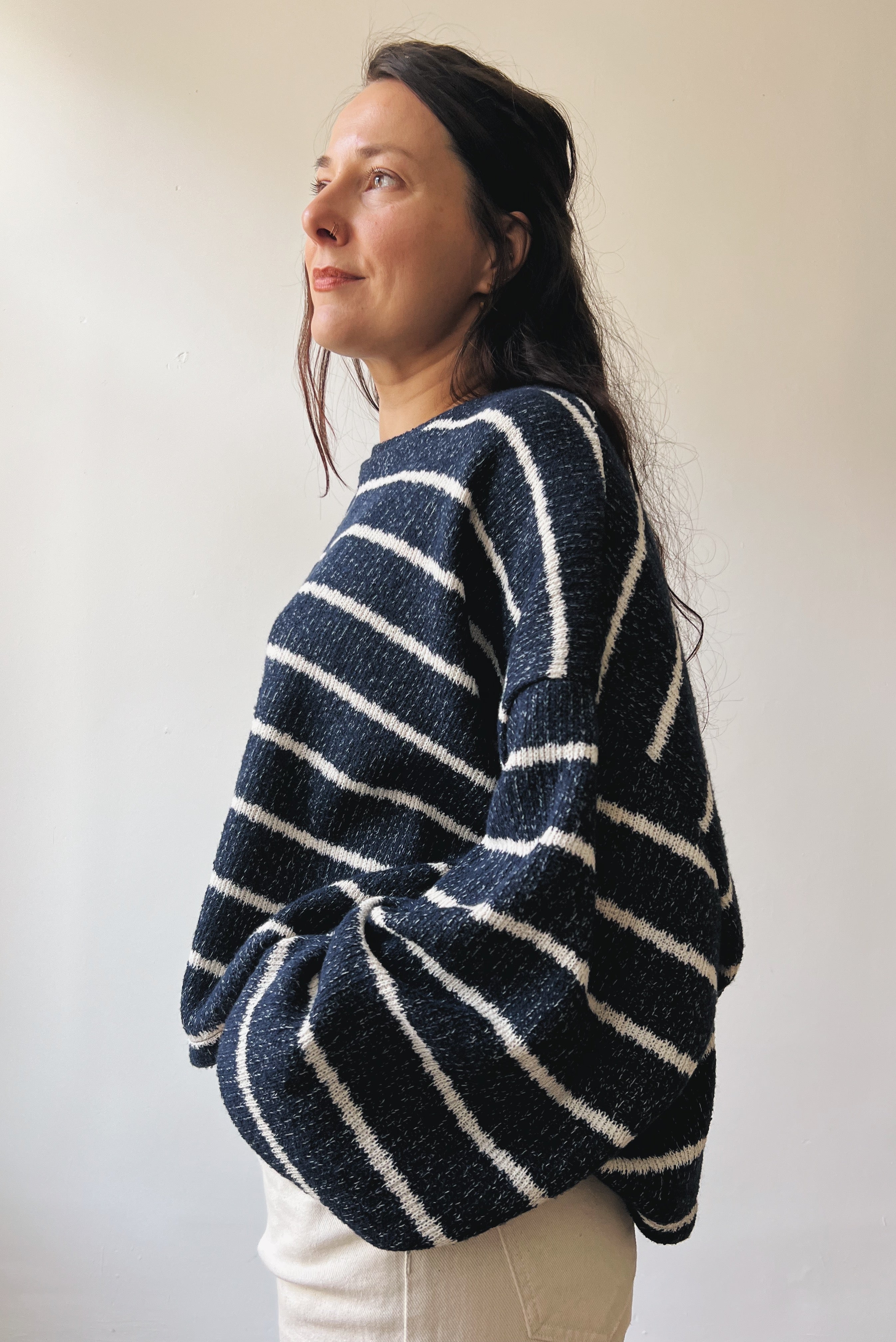 Woman wearing a blue-white striped sweater against a plain background