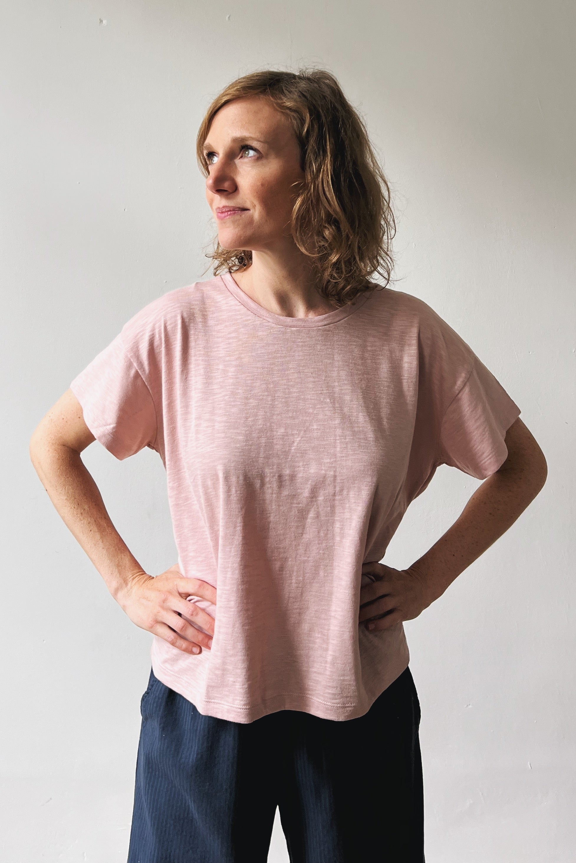 Woman wearing a pink t-shirt and blue pants 